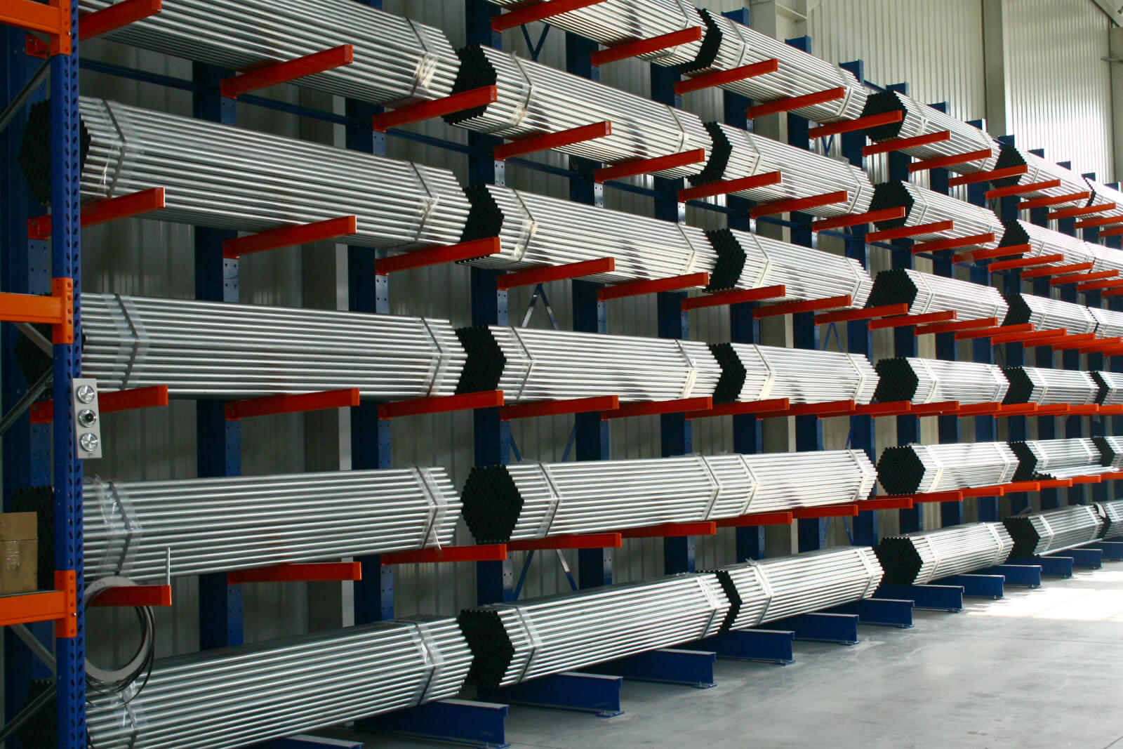 Rury metalowe przechowywane na systemie regałów wspornikowych w magazynie.