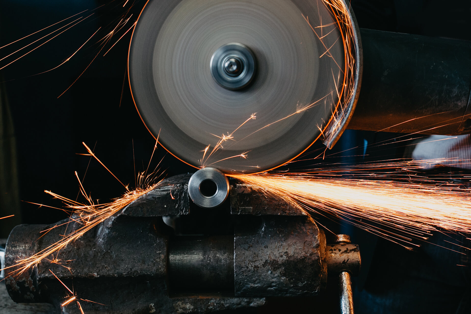 Szlifowanie metalu za pomocą iskier. Proces obróbki metali. Scena przemysłowa.